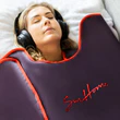 Woman relaxing with headphones and weighted blanket.